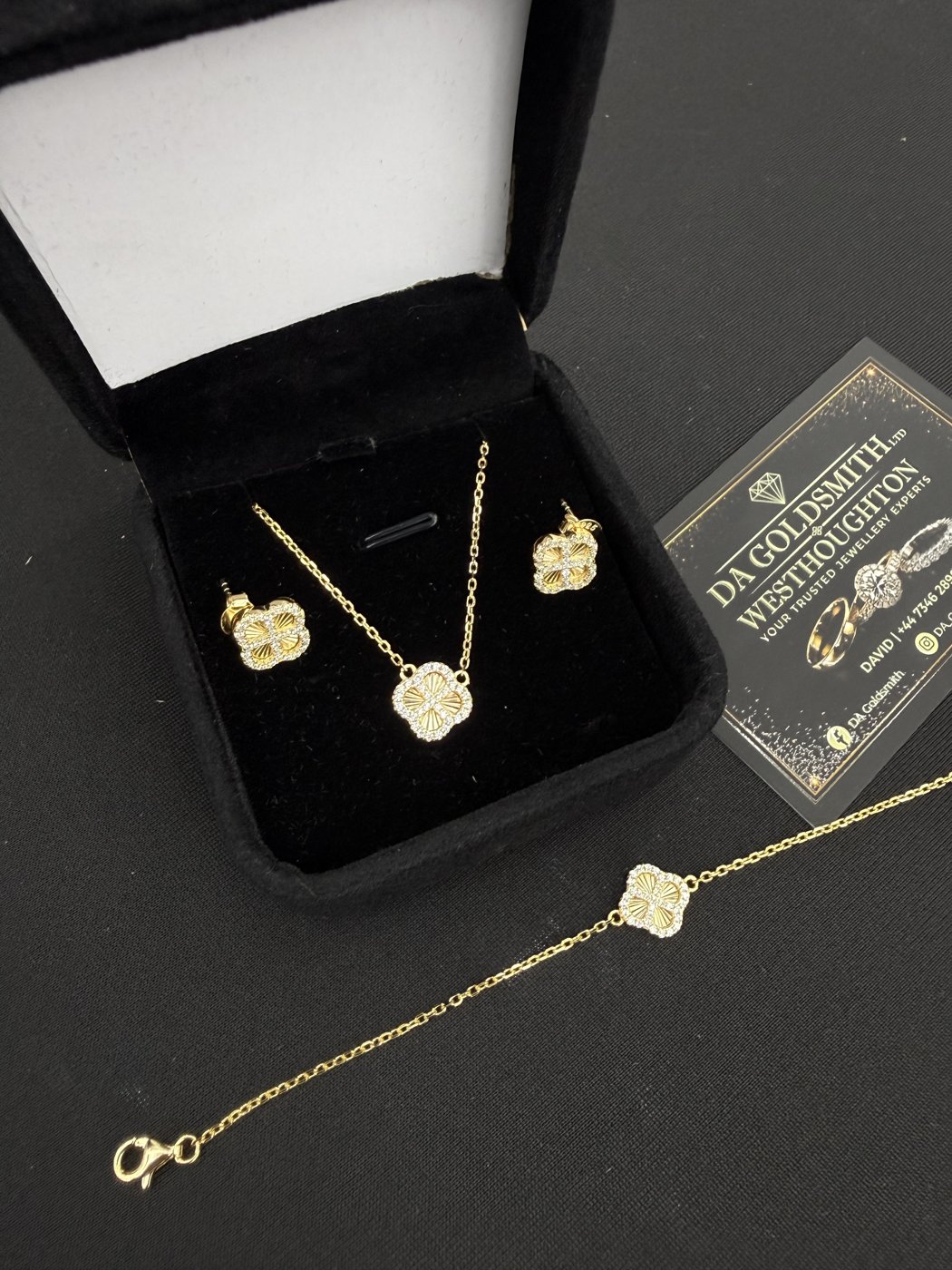 Pendant, earrings and bracelet arranged beside a jewellery box