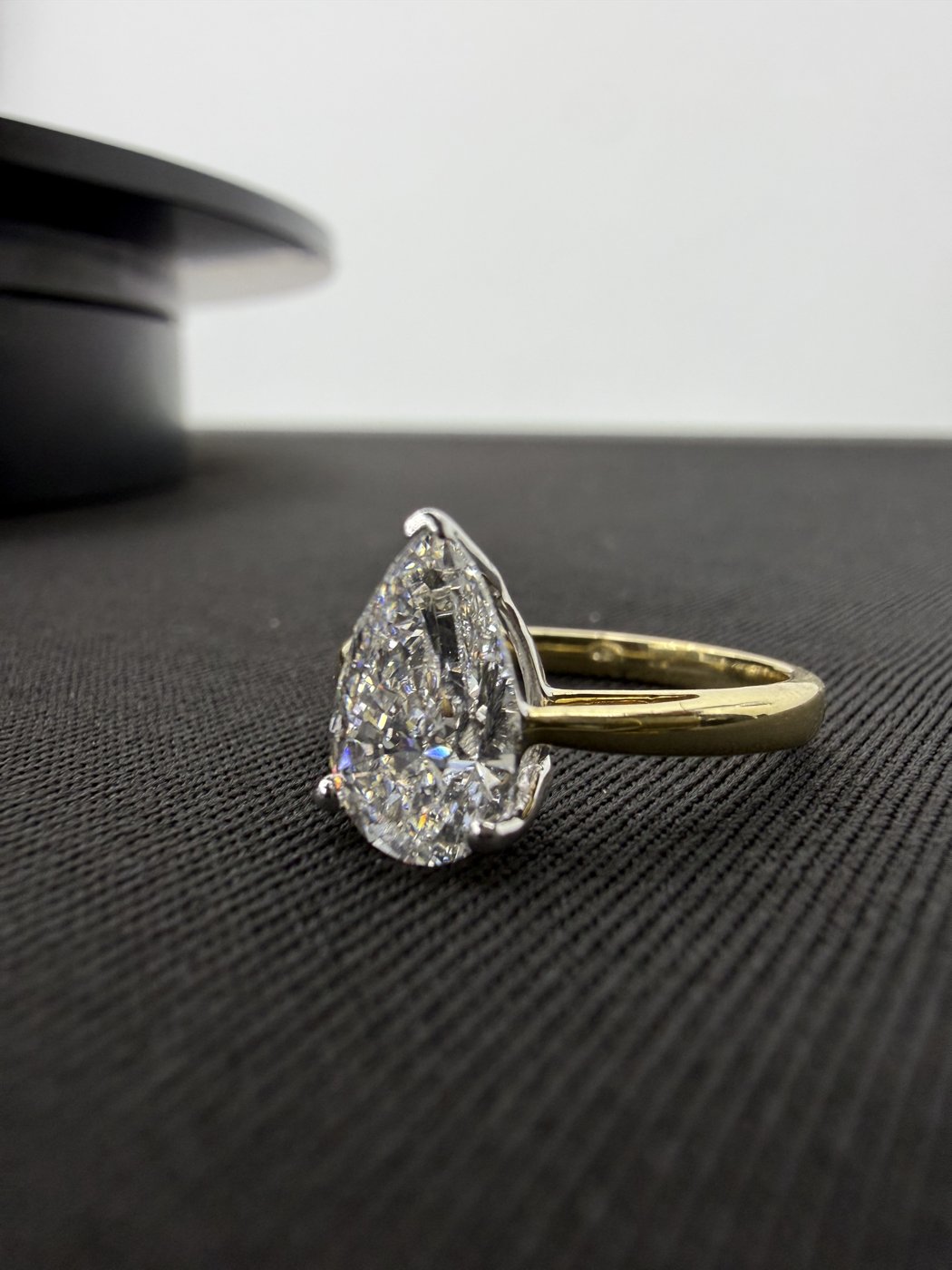 Pear-shaped ring displayed on a dark surface
